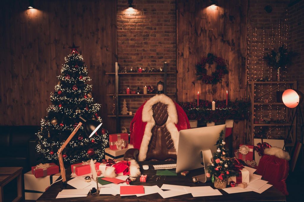 Photo of santa claus workplace christmas tree desk clothes xmas eve holly indoors inside home apartment.